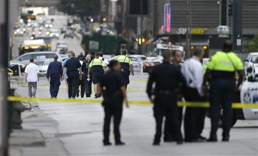 Investigators walk the scene of a shooting in downtown Dallas, Friday, July 8, 2016. Snipers opened fire on police officers in the heart of Dallas during protests over two recent fatal police shootings of black men. AP