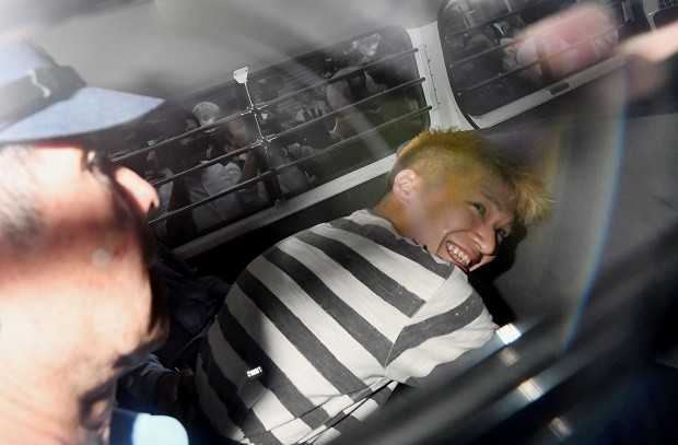 Satoshi Uematsu, the suspect of Tuesday's knife attack at a home for the mentally disabled, sits inside a police van as he leaves a police station in Sagamihara, outside Tokyo to be sent to prosecutors Wednesday, July 27, 2016. The deadliest mass killing in Japan in the post-World War II era raised questions about whether Japan's reputation as one of the safest countries in the world is creating a false sense of security. AP