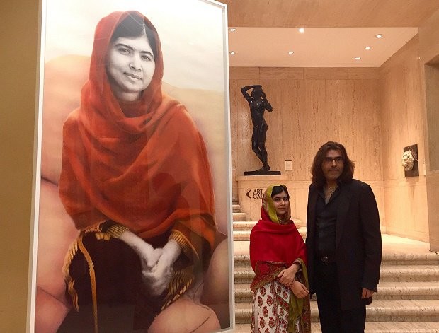 Schoolgirl Nobel Peace Prize winner Malala Yousafzai stands with artist Nasser Azam at the unveiling of a new portrait entitled Malala, at the Barber Institute of Fine Arts, Birmingham, England, Sunday Nov. 29, 2015. Malala narrowly avoided death when she was 15-years old after being shot in the head by a Pakistani Taliban attacker for her outspoken campaigning advocating education for girls. PA via AP