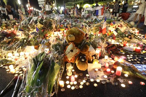 A teddy bear is laid with flowers and candles to honor the victims of an attack, on the Promenade des Anglais, near the area where a truck mowed through revelers in Nice, southern France, Saturday, July 16, 2016. A large truck mowed through revelers gathered for Bastille Day fireworks in Nice, killing scores of people and sending people fleeing into the sea as it bore down for more than a mile along the Riviera city's famed waterfront promenade. AP Photo/Claude Paris