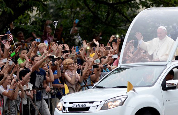 Pope Francis greets faithfuls as he leaves in popemobile the Wawel royal castle in Krakow, on July 27, 2016 as part of his visit to the World Youth Days (WYD). Pope Francis heads to Poland for an international Catholic youth festival with a mission to encourage openness to migrants. / AFP PHOTO / JANEK SKARZYNSKI