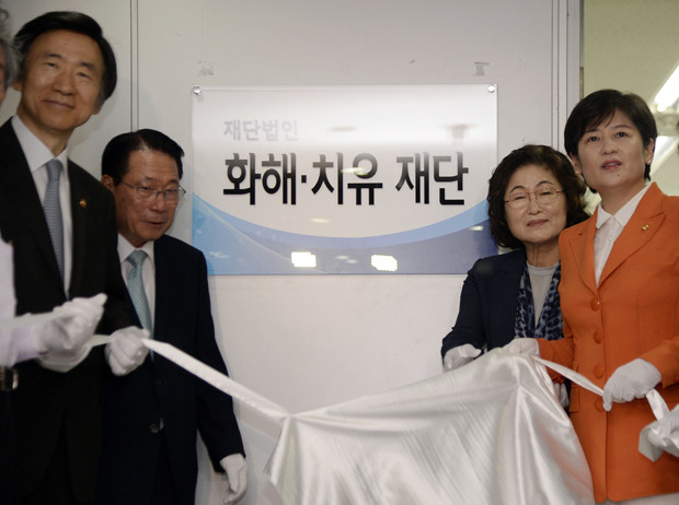 South Korean Foreign Minister Yun Byung-se, left, Kim Tae-hyun, second right, head of a preparation committee for a fund aimed at compensating Korean victims of Japanese wartime military brothels, and Kang Eun-hee, right, minister of Gender Equality and Family attend the office opening ceremony of the committee in Seoul, South Korea Thursday, July 28, 2016. The sign reads Reconciliation and Healing Foundation.  (Song Kyung-seok/Pool Photo via AP)