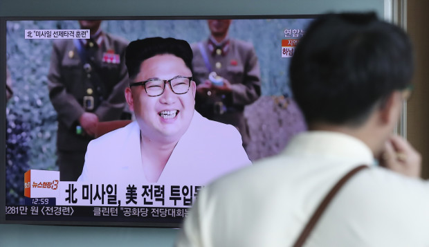 A man walks by a TV screen showing the North Korean leader Kim Jong Un at the Seoul Train Station in Seoul, South Korea, Wednesday, July 20, 2016. North Korea said Wednesday it test-fired ballistic rockets as part of a simulated pre-emptive attack on ports and airfields in South Korea, in a likely reference to the three missile launches that Seoul says the North carried out a day earlier. The letters, the top left, read: "North Korea, Missile pre-emptive attack drill." (AP Photo/Lee Jin-man)