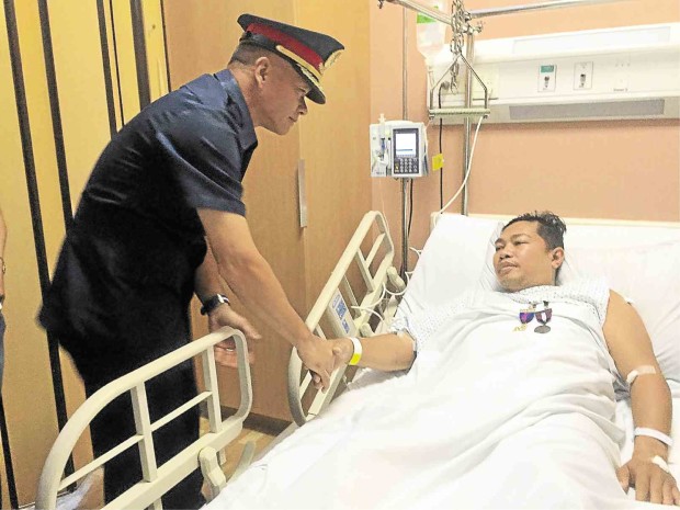 MEDALS FOR THE WOUNDED  Chief Supt. Oscar Albayalde, NCRPO director,  congratulates PO2 Alvin Taduyo at the hospital on Friday. Annelle Tayao-Juego