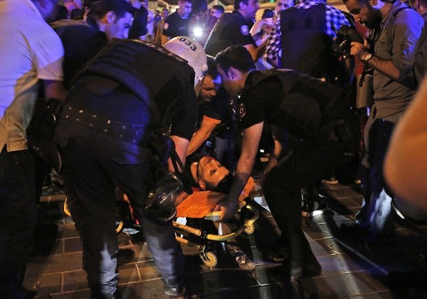 An injured man is attended by police when Turkish forces soldiers opened fire to disperse the crowd in Istanbul's Taksim square, early Saturday, July 16, 2016. Members of Turkey's armed forces said they had taken control of the country, but Turkish officials said the coup attempt had been repelled early Saturday morning in a night of violence, according to state-run media. AP 