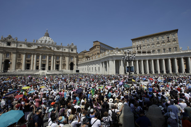 People crowd St.Peter's Square at the Vatican as Pope Francis delivers his blessing from the window of his studio, Sunday, July 3, 2016. The pontiff has led tens of thousands of pilgrims, tourists and Romans in silent prayer for the dozens of people who perished in militant attacks on a Dhaka, Bangladesh, restaurant and two bombings in Baghdad. (AP Photo/Andrew Medichini)