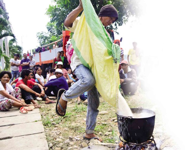 A FARMER cooks rice for his fellow protesters during a camp-out outside the Department of Social Welfare and Development Office in Cagayan de Oro. The farmers held a brief volley to demand food aid. JIGGER J. JERUSALEM/INQUIRER MINDANAO