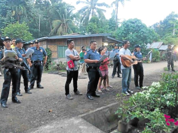 POLICEMEN in Kapalong town in Davao del Norte province serenade a community where a drug suspect lives. CONTRIBUTED PHOTO