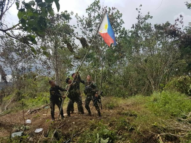 Army Scout Rangers hoist the Philippine flag on Friday after gaining control of one of the defensive positions of Abu Sayyaf in Basilan. The military offensives against the terror group continue.  CONTRIBUTED PHOTO
