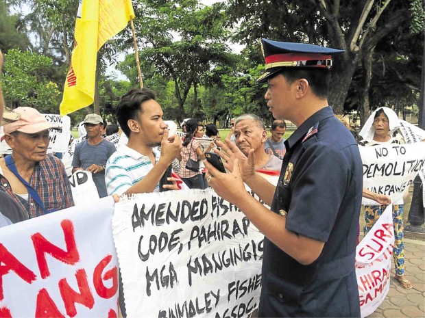 IN LINGAYEN town, Pangasinan province, militant group leaders talk with a police officer during a rally in support of President Duterte. They also aired a wish list for his administration.     GABRIEL CARDINOZA/INQUIRER NORTHERN LUZON