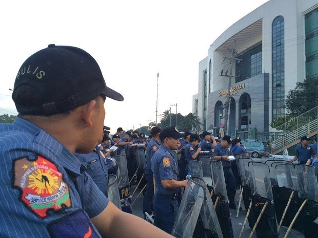 Policemen stand outside the Sandiganbayan building at the corner of Commonwealth Avenue and Batasan Road in Quezon City on Monday morning, July 25, 2016. They are providing security for the first State of the Nation Address of President Rodrigo Duterte. GRIG MONTEGRANDE / PHILIPPINE DAILY INQUIRER