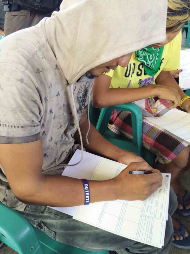 A ZAMBOANGA CITY resident wearing a Duterte baller ID signs an information sheet and affidavit of undertaking for surrendered users and pushers. JULIE S. ALIPALA/INQUIRER MINDANAO
