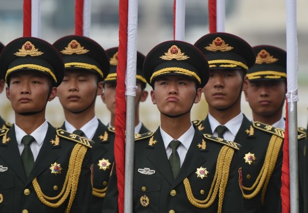 Members of a Chinese military honour guard prepare before taking part in a welcome ceremony for Greek Prime Minister Alexis Tsipras outside the Great Hall of the People in Beijing on July 4, 2016.  Tsipras is on a state visit to China. / AFP PHOTO / GREG BAKER