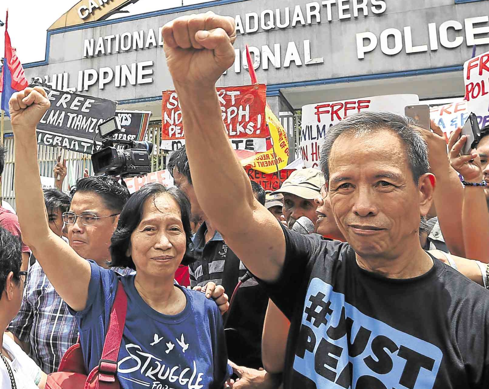In this file photo, Communist Party of the Philippines leaders (right and left) Benito Tiamzon and his wife, Wilma, raise clenched fists as they walk out of police detention on August 19, 2016, to join rebel negotiators in peace talks in Norway. PHILIPPINE DAILY INQUIRER / NIÑO JESUS ORBETA