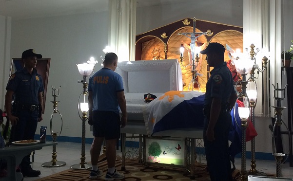 A fellow policeman pays his last respects to Senior Insp. Mark Gil Garcia, who was shot dead while arresting an alleged drug pusher in Antipolo City on Friday night. Garcia's remains lie at the Multipurpose Hall of the PNP's Rizal provincial office in the town of Taytay. JODEE AGONCILLO / PHILIPPINE DAILY INQUIRER