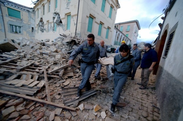 Rescuers carry a man from the rubble after a strong earthquake hit Amatrice on August 24, 2016.  Central Italy was struck by a powerful, 6.2-magnitude earthquake in the early hours, which has killed at least three people and devastated dozens of mountain villages. Numerous buildings had collapsed in communities close to the epicenter of the quake near the town of Norcia in the region of Umbria, witnesses told Italian media, with an increase in the death toll highly likely. / AFP PHOTO / FILIPPO MONTEFORTE