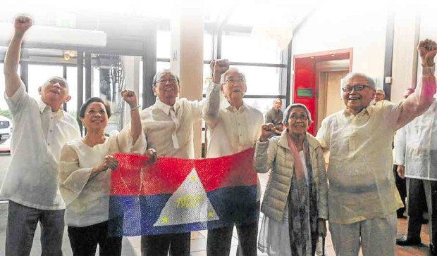 WINNING MOMENT Members of the National Democratic Front of the Philippines (from left) Fidel Agcaoili, Coni Ledesma, Jose Maria Sison, Luis Jalandoni, Juliet de Lima and Asterio Palima raise their fists and hold an NDFP flag to mark the end of the first round of peace talks with the government panel in Oslo, Norway. EDRE OLALIA/CONTRIBUTOR 