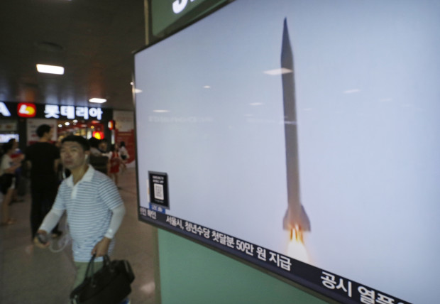 A man passes by a TV news program with  file footage of a North Korean rocket launch at the Seoul Railway Station in Seoul, South Korea, Wednesday, Aug. 3, 2016. North Korea fired a ballistic missile into the sea on Wednesday South Korea's military said, the fourth reported weapons launch the North has carried out in about two weeks. (AP Photo/Ahn Young-joon)