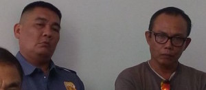PO3 Renato Inot (in uniform) of the Mandaue City Police and his cousin, Adelcos Alonzo, are investigated for mauling a truck driver and pointing a gun at him. (CDN FILE PHOTO / JUNJIE MENDOZA)