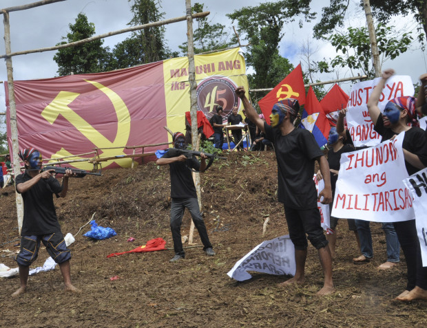 FILE - In this Dec. 26, 2013, file photo, communist New People's Army (NPA) rebels perform in the hinterlands of Davao in Southern Philippines. Philippine communist rebels vowed Although less numerous and less violent than Muslim separatist rebels in the country’s south, the Maoists have outlived successive Philippine administrations and held out against constant military and police offensives, relying on clandestine cells to pass on orders to members from their exiled leaders. (AP Photo, File)
