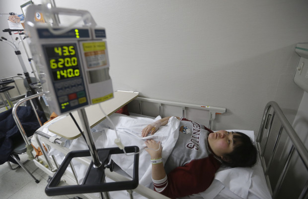 In this Jan. 27, 2016 photo, Kim Mi-seon, 36, former Samsung display factory worker who lost sight in 2014 since diagnosed with multiple sclerosis, lies on a hospital bed in Seoul, South Korea. An Associated Press investigation has found South Korean authorities have, at Samsung’s request, repeatedly withheld crucial information about the chemicals that workers were exposed to at its computer chip and liquid crystal display factories. Workers who have fallen ill due to the chemicals have the right to access such data so they can apply for workers’ compensation from the state. Without this information, government officials commonly reject their cases. (AP Photo/Ahn Young-joon)
