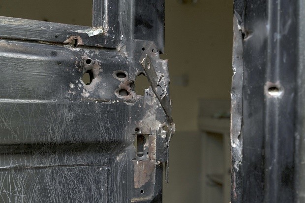 In this photo taken Wednesday, Aug. 3, 2016 and released by Adriane Ohanesian, bullet holes are seen in a metal door that was shot open at the Terrain compound after it was looted the previous month in the capital Juba, South Sudan. On July 11, South Sudanese troops, fresh from winning a battle in Juba over opposition forces, went on a nearly four-hour rampage through a residential compound popular with foreigners, in one of the worst targeted attacks on aid workers in South Sudan's three-year civil war. AP