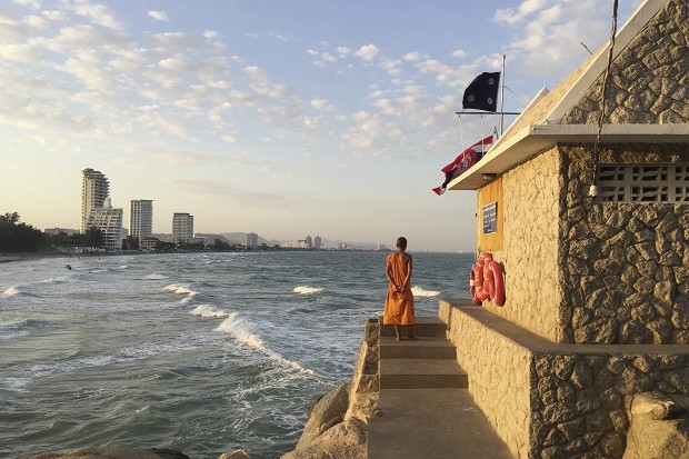 In this Dec. 31, 2015, photo, a Buddhist monk looks out on the beach in the resort town of Hua Hin, 240 kilometers (150 miles) south of Bangkok, Thailand. Police on Friday, Aug. 12, 2016, have confirmed that another person has died in a new bomb blast in the southern resort city of Hua Hin, hours after twin explosions killed one woman and wounded several others late Thursday. AP