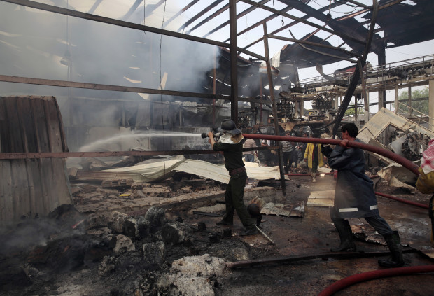 Firefighters work to extinguish fire at a food factory hit by Saudi-led airstrikes in Sanaa, Yemen, Tuesday, Aug. 9, 2016. A Yemeni factory official and two medics say a Saudi-led airstrike has killed 14 civilians working on an overnight shift in the capital, Sanaa. They say the airstrikes were targeting Yemen's Shiite rebels in Sanaa but instead one of them hit a food factory. The heavy bombardment comes on the heels of the failed U.N. peace talks in Kuwait between Yemen's internationally-recognized government and the Shiite rebels known as Houthis. (AP Photo/Hani Mohammed)