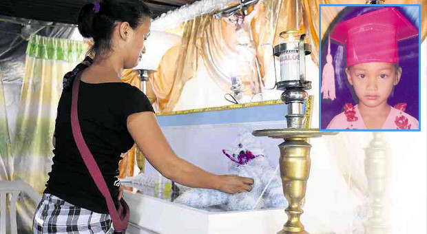 YOUNG VICTIM A relative grieves beside the coffin of Danica May (inset), 5, who was felled by an assassin’s bullet intended for her grandfather on Tuesday. WILLIE LOMIBAO/INQUIRER NORTHERN LUZON