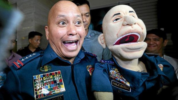 SIDESHOW Director General Ronald “Bato” dela Rosa, chief of the Philippine National Police, gamely poses with Bato the Puppet during a celebration at Camp Crame, Quezon City.           NIÑO JESUS ORBETA