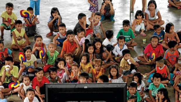 EVACUATION EVENT Children stay glued to the television at an evacuation center in Malanday Elementary School in Marikina City, where they and their parents are seeking shelter from incessant heavy rain brought by the southwest monsoon. RICHARD A. REYES