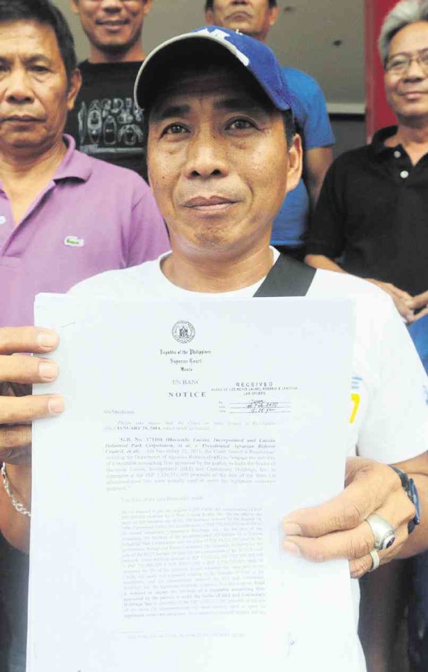  ELMER Mallari, one of the farmers demanding that government honor a land conversion deal in Hacienda Luisita, shows a copy of the Supreme Court resolution allowing the conversion.          GRIG C. MONTEGRANDE