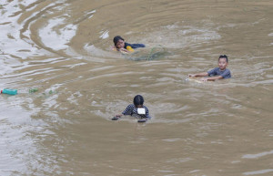 Children play in floodwaters after heavy southwest monsoon rains inundated low-lying areas of San Mateo and nearby provinces Sunday, Aug. 14, 2016, in San Mateo township, Rizal province east of Manila, Philippines. Thousands of residents living along a swollen river were forced to evacuate following heavy rains that inundated low-lying areas in Metropolitan Manila and at least four provinces in the country's Luzon island. AP Photo
