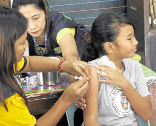 ANTICANCER Health workers in Narvacan town in Ilocos Sur province give a pupil vaccine to protect her from the human papilloma virus. LEONCIO BALBIN JR./Contributor