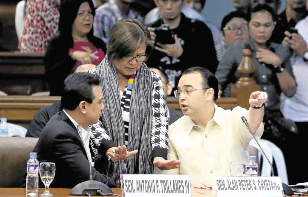 MIDDLE GROUND   Sen. Leila de Lima tries to pacify her colleagues, Alan Peter Cayetano and Antonio Trillanes IV, as tensions rise during the Senate hearing on extrajudicial killings. RICHARD A. REYES 