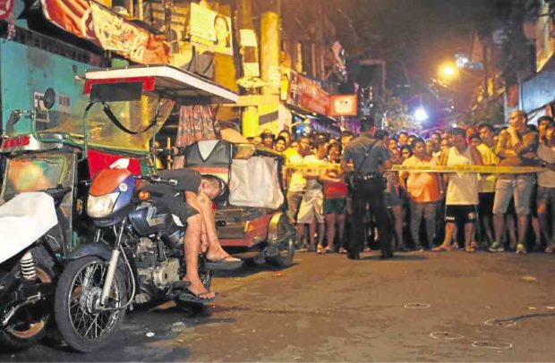 STA. ANA STREET SHOCKER. The Manila police keep a crowd of onlookers at a distance from the body of Sandrex Ampo-an, who was shot dead by four unidentified gunmen late Friday night while seated on a tricycle near his Punta, Sta. Ana, residence. RAFFY LERMA