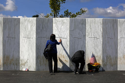 FILE- In this Sept. 11, 2015 file photo, a visitor pauses at the Wall of Names after a Service of Remembrance at the Flight 93 National Memorial in Shanksville, Pa. Victims' relatives and dignitaries will convene Sunday, Sept. 11, 2016, at the site for one of the constants in how America remembers 9/11 after 15 years, the anniversary ceremony itself. (AP Photo/Gene J. Puskar, File)
