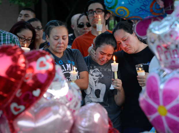 FILE - In this Thursday Aug. 25, 2016 file photo, from left to right, Nicole Maldonado, Myriah Flores, and her mother Sharlene Benavidez attend a candlelight vigil for 10-year-old Victoria Martens at the apartment complex, in Albuquerque, N.M., where the young girl lived and was killed.  The mother of Victoria Martens told police she sought men online and at work to sexually assault her daughter before her death, according to warrants obtained by the Albuquerque Journal. Michelle Martens told police she had set up encounters with at least three men to sexual assault her daughter whose brutal death spark vigils and outcry across New Mexico.  (Jim Thompson/The Albuquerque Journal via AP,File)