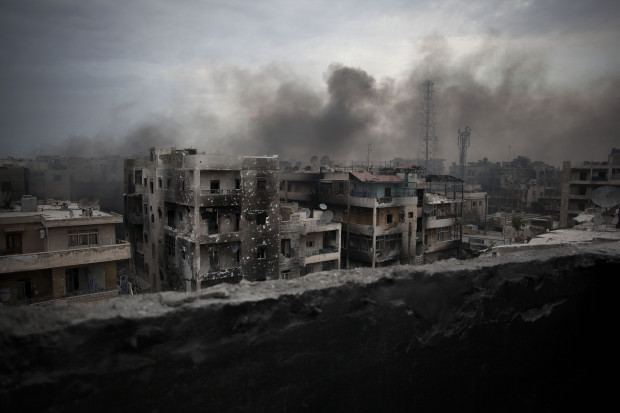 FILE - In this Tuesday, Oct. 2, 2012 file photo, smoke rises over Saif Al Dawla district, in Aleppo, Syria. Residents in the rebel-held districts of Aleppo have a reprieve from the incessant bombings by Syrian government warplanes and the promise of an end to the crippling siege that has left produce stalls bare. (AP Photo/ Manu Brabo, File)