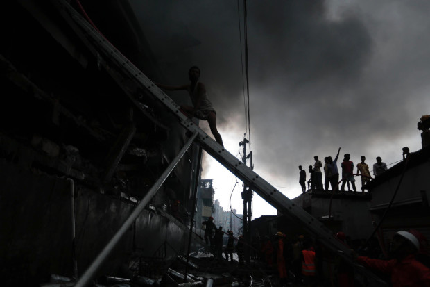 Firefighters are silhouetted against smoke as they work to put out a fire at a packaging factory in Tongi industry area outside Dhaka, Bangladesh, Saturday, Sept. 10, 2016. A boiler exploded and triggered a fire at a packaging factory near Bangladesh's capital. (AP Photo/A. M. Ahad)