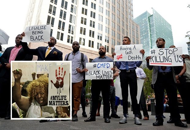 People gather at Trade and Tryon Streets in uptown Charlotte, N.C., in protest of a police officer's fatal shooting Tuesday of Keith Lamont Scott, Wednesday afternoon, Sept. 21, 2016. Scott was shot at The Village at College Downs apartment complex in the University City area. Authorities in Charlotte tried to quell public anger Wednesday after a police officer shot a black man, but a dusk prayer vigil turned into a second night of violence, with police firing tear gas at angry protesters and a man being critically wounded by gunfire.  (Jeff Siner/The Charlotte Observer via AP)