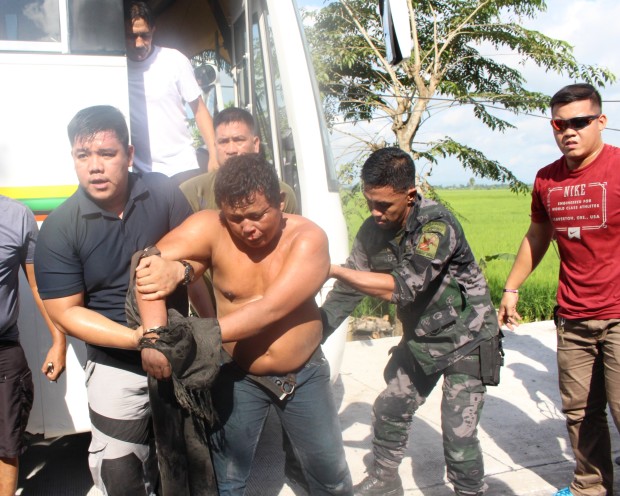 Plainclothes policemen grab Bayani Dalanon Yutiga after he reportedly held a two-year-old boy hostage on a bus in Oas, Albay, on Monday. The boy was released safe and Yutiga was detained at the Oas town jail. MICHAEL JAUCIAN / INQUIRER SOUTHERN TAGALOG