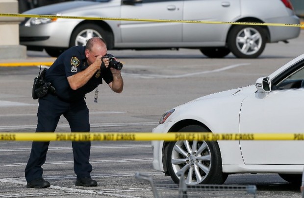 HOUSTON, TX - SEPTEMBER 26: Houston Police investigators photograph a vehicle that received gunshot damage during a scene where nine were wounded in a strip mall shooting on September 26, 2016 in Houston, Texas. The gunman was shot and killed by police officers. Three victims have been transported to Southwest Memorial Hospital, one has been taken to Ben Taub General Hospital and two have been transported to Memorial Hermann - Texas Medical Center.   Bob Levey/Getty Images/AFP