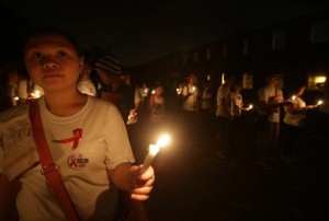In this Dec. 1, 2013 file photo, volunteers of the Manila Red Cross Youth hold candles as they observe World AIDS Day in Manila, Philippines. AP 