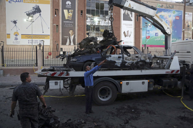 Iraqi security forces clean up the site in the aftermath of car bomb explosion Baghdad, Iraq, Saturday, Sept. 10, 2016. Late Friday night a car bomb targeting a shopping mall in eastern Baghdad killed and wounded civilians and policemen, officials said. (AP Photo/Karim Kadim)