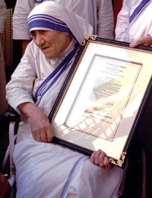 In this Saturday, Nov. 16, 1996 file photo, Mother Teresa holds the resolutions of honorary American citizenship after they were presented to her by American Ambassador to India Frank G. Wisner at the Missionaries of Charity in KolKata, formerly known as Calcutta, India. With Sunday, Sept. 4, 2016 making the canonization of Mother Teresa, Pope Francis honored the tiny nun who cared for the "poorest of the poor" as the epitome of his call for mercy. Here are some significant dates in the life of the Catholic Church's newest saint. (AP Photo, File)