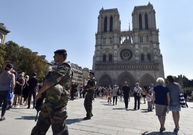 (FILES) This file photo taken on August 15, 2016 shows French soldiers patrolling in front of Notre Dame cathedral in Paris as part of the Sentinelle military force security mission while people queue for the mass for the feast of the Assumption on August 15, 2016. French anti-terror police were holding two suspects on September 7, 2016 after finding several gas cylinders in a car near Paris's Notre Dame cathedral, sources close to the investigation said. No detonators were found in the vehicle, which was discovered abandoned at the weekend (September 3 and 4, 2016), the sources said. The car's owner and an associate, both known to police, were arrested on September 6, 2016 they said, adding a preliminary investigation had been launched. / AFP PHOTO / ALAIN JOCARD