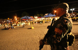 A Philippine soldier keeps watch at a blast site at a night market that has left several people dead and wounded others in southern Davao city, Philippines late Friday Sept. 2, 2016. The powerful explosion in Philippine President Rodrigo Duterte's hometown in the southern Philippines took place amid a security alert due to a major offensive against Abu Sayyaf militants in the region, officials said. (AP Photo/Manman Dejeto)