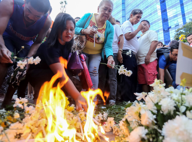 Residents place flowers at the makeshift memorial at the site of Friday night's explosion in Davao city, southern Philippines, Saturday, Sept. 3, 2016. Philippine President Rodrigo Duterte declared a nationwide "state of lawlessness" Saturday after suspected Abu Sayyaf extremists detonated a bomb at the night market in Davao city, his hometown. (AP Photo/Manman Dejeto)