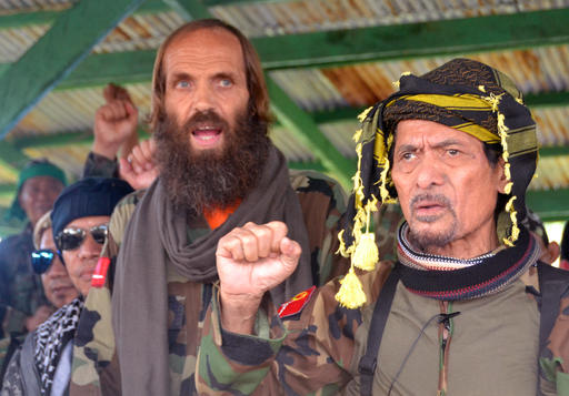 Released Norwegian hostage Kjartan Sekkingstad, second right, stands next to Moro National Liberation Front Chairman  Nur Misuari, right, after being turned over by ransom-seeking Abu Sayyaf extremists in Indanan township on Jolo island in southern Philippines Sunday, Sept. 18, 2016. Sekkingstad, who was kidnapped last year along with two Canadians and a Filipino, was released Saturday and was turned over Sunday to Misuari, who in turn turned him over to Presidential adviser Jesus Dureza. (AP Photo/Nickee Butlangan)